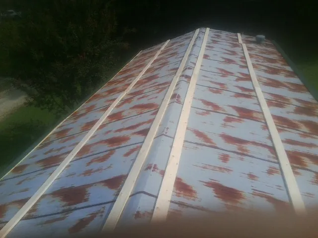 Rusted metal roof panels with new wood purlins before replacement — Storm Damage Roof Repair in Wilkinson by Roofing Brothers